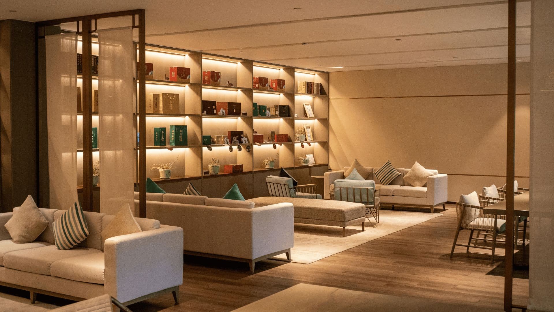 Hotel lounge with lit shelves displaying boxed brand products