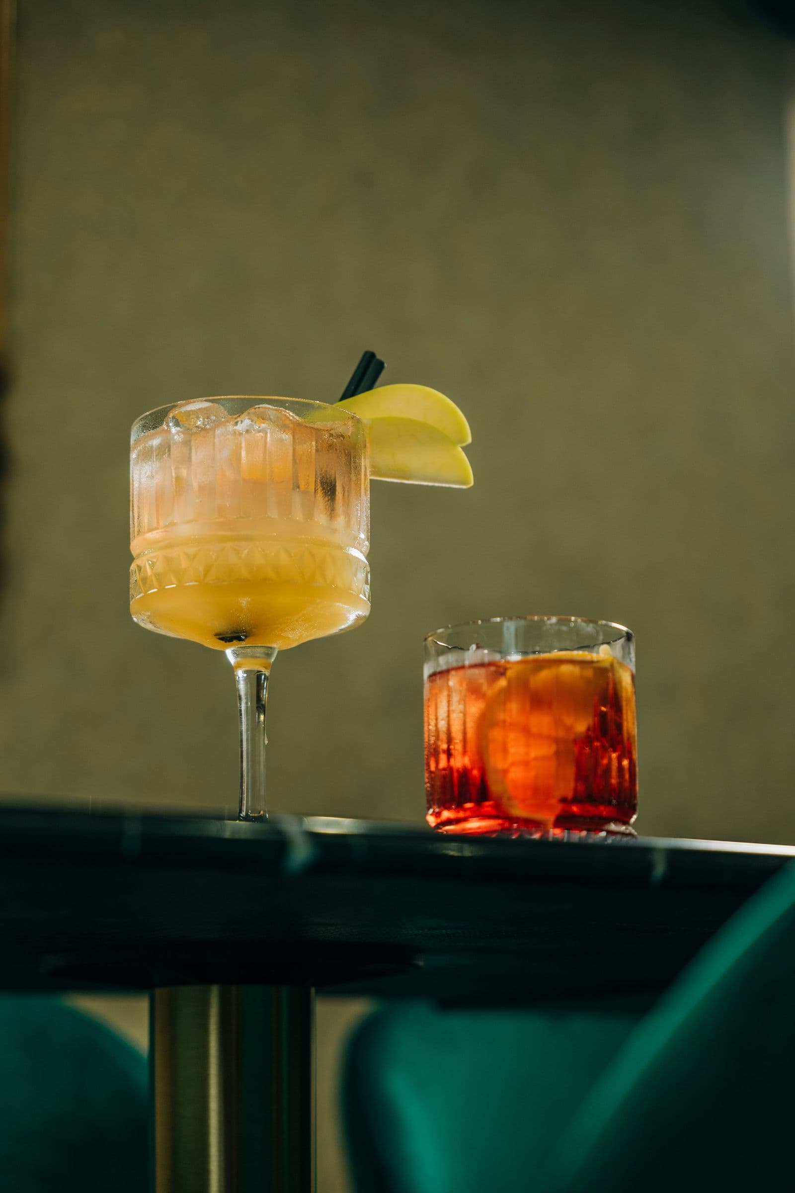 Two cocktails on a bar ledge