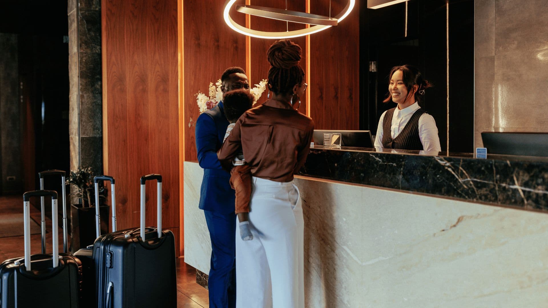 Family checking in at a hotel reception desk