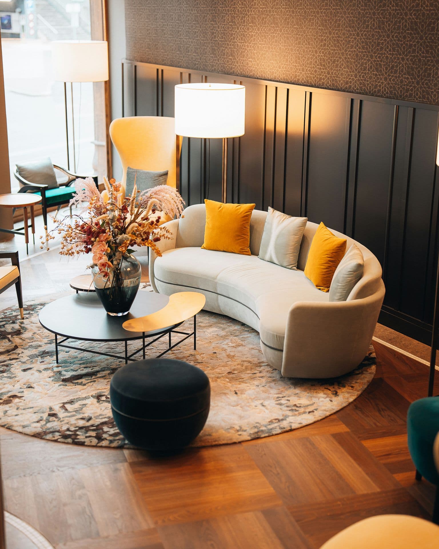 Hotel lobby lounge with a curved sofa and floor lamps