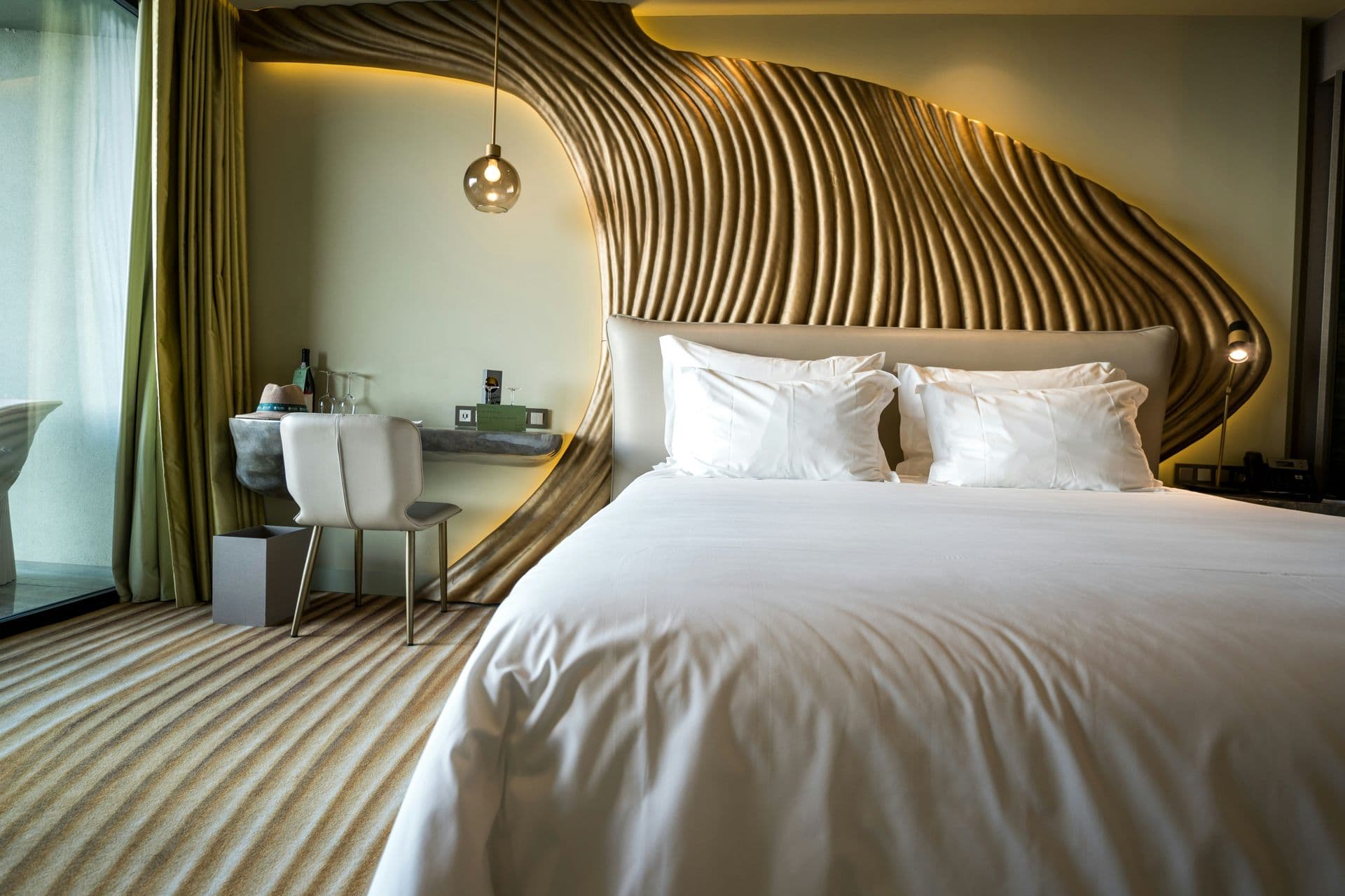 Hotel bedroom with a sculpted, backlit headboard
