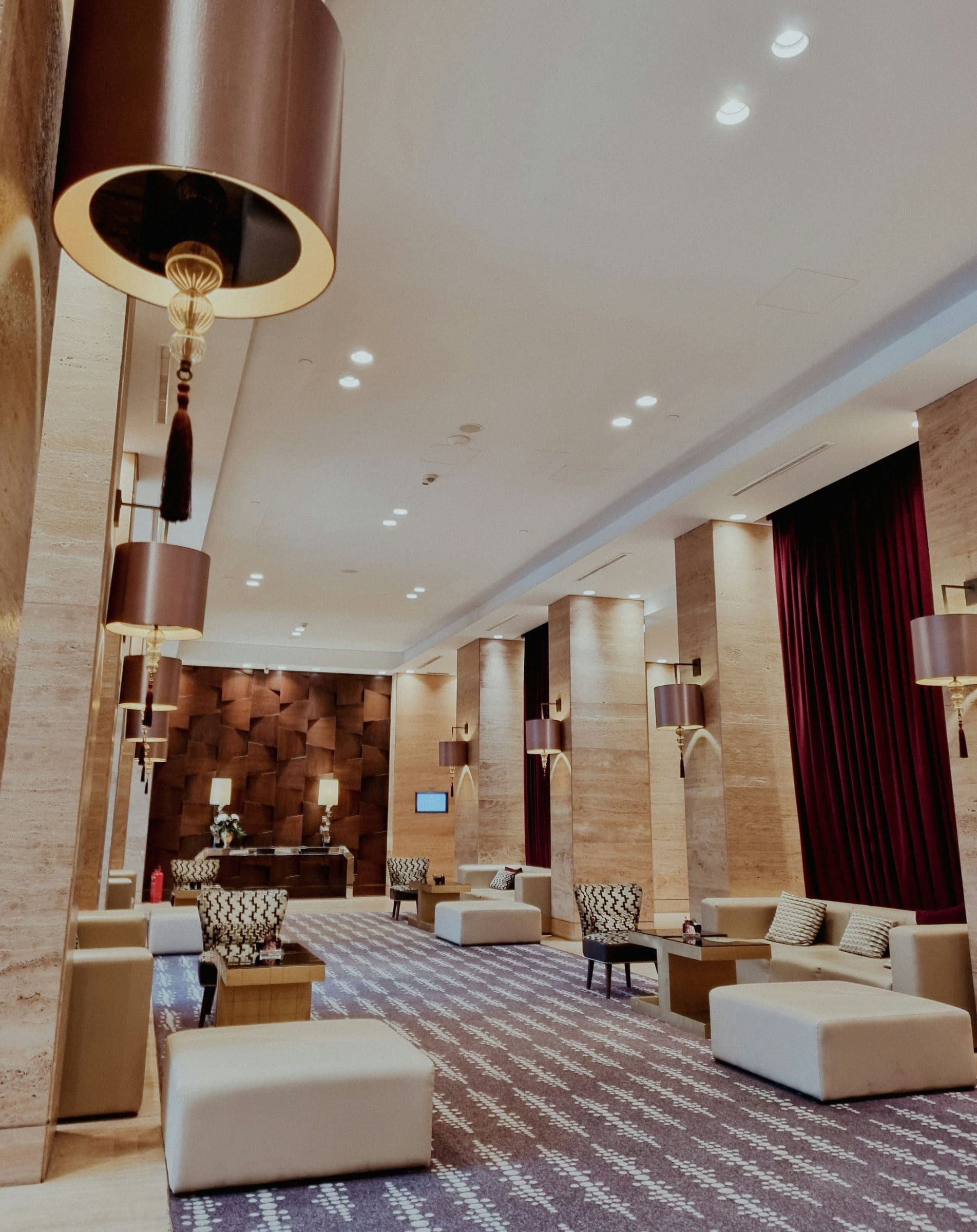 Travertine hotel lounge with deep red curtains